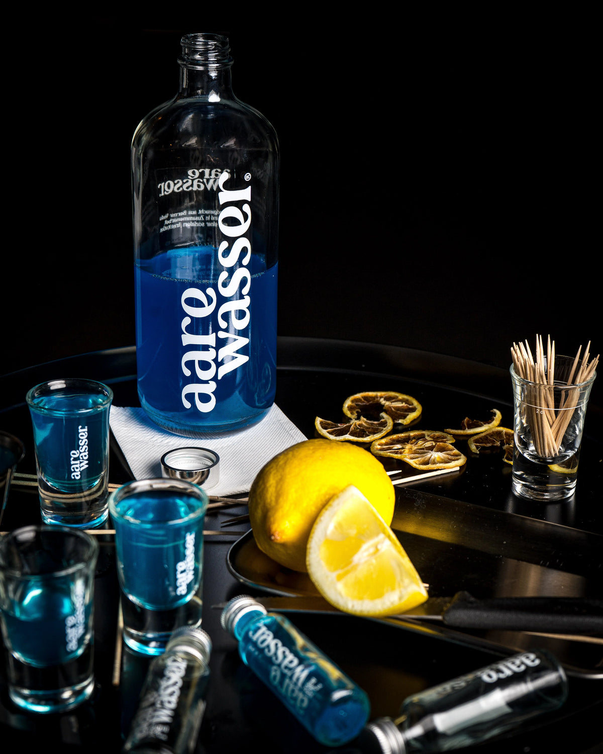 Aarewasser Flasche mit Shots und Zitronen